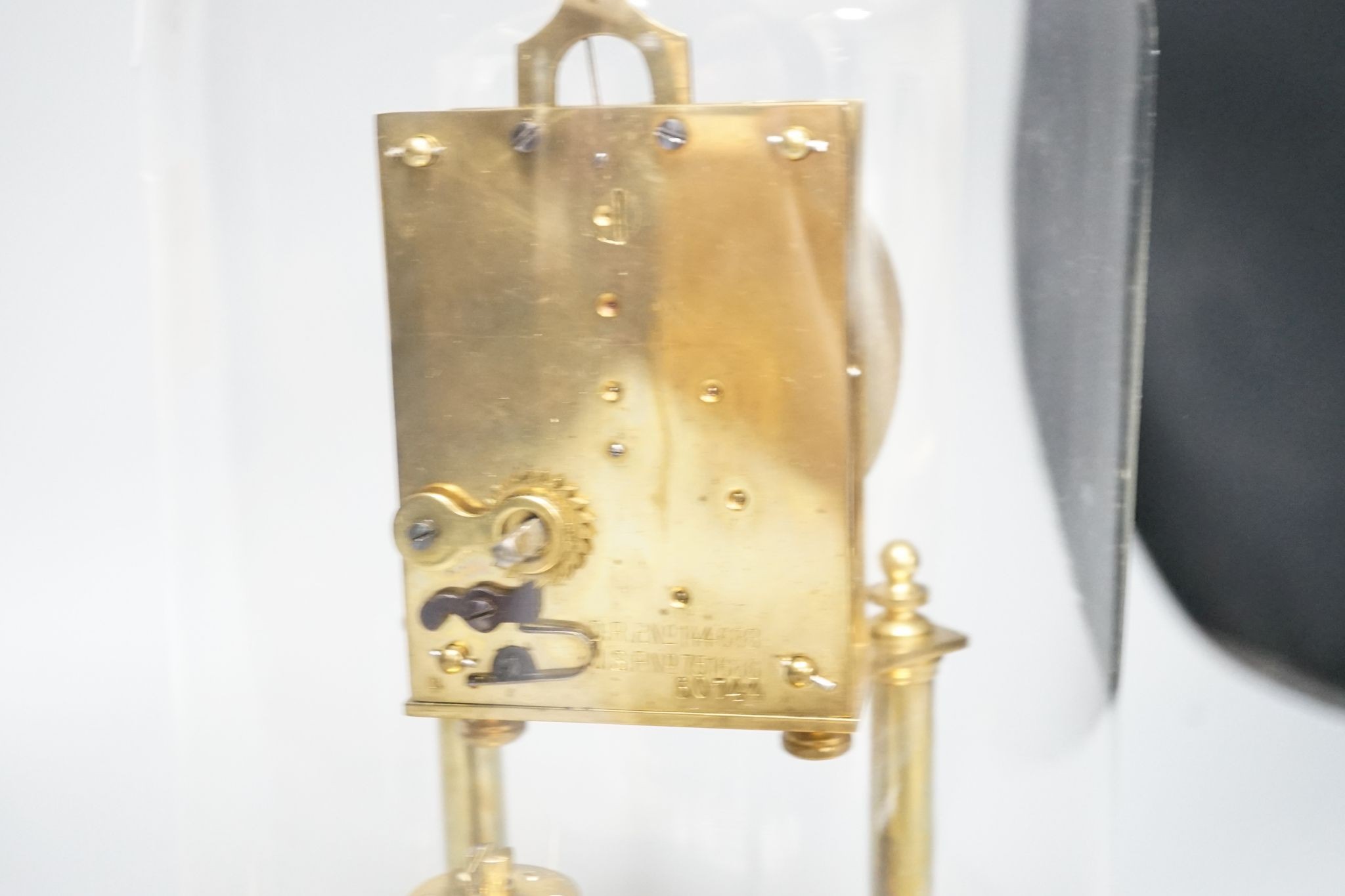 An early 20th century month going mantel timepiece, with a silk suspension, under a glass dome 29cm